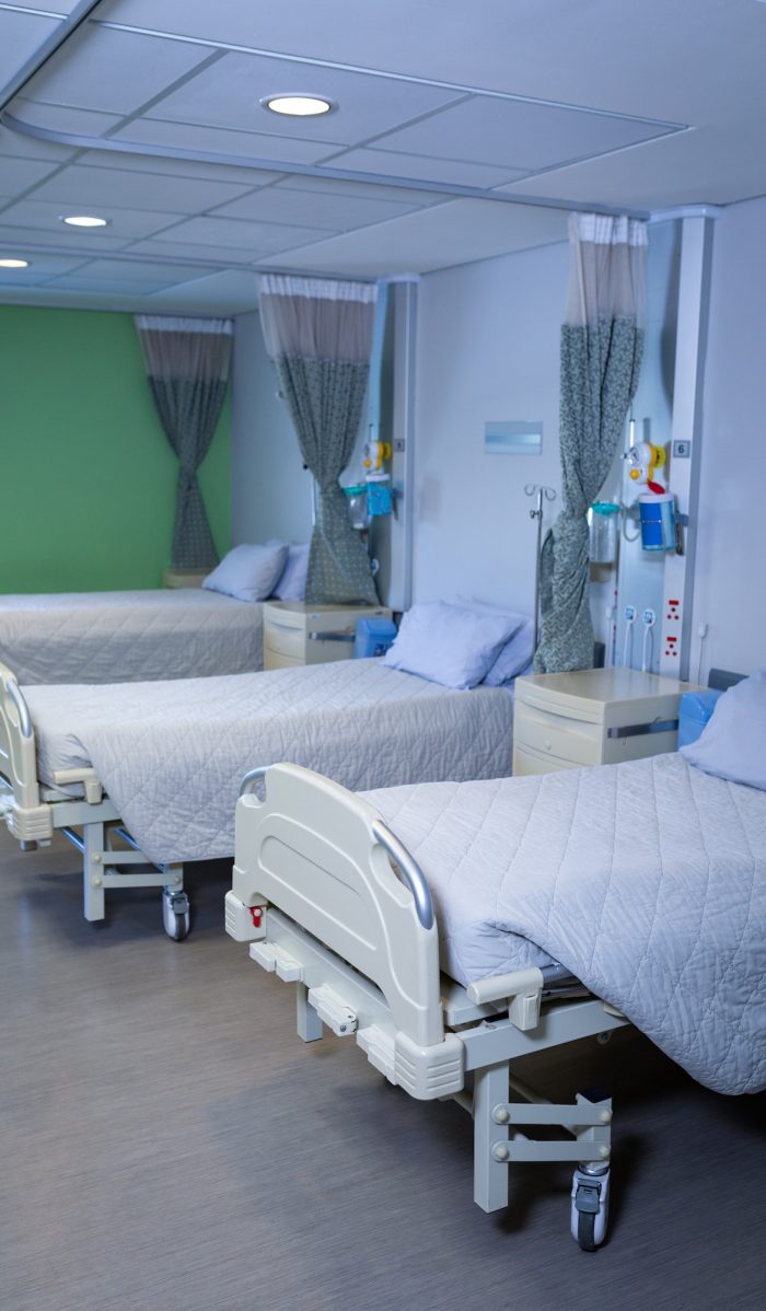 Front view of row of empty hospital beds in hospital