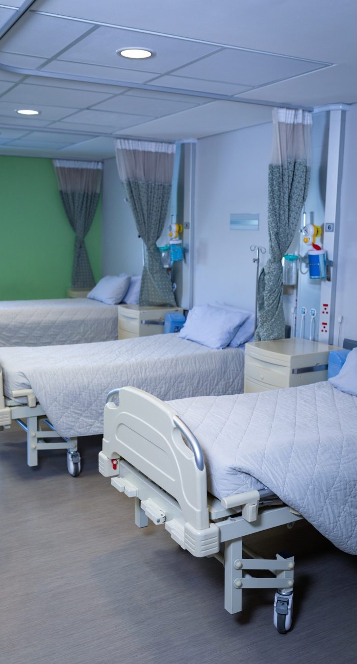 Front view of row of empty hospital beds in hospital